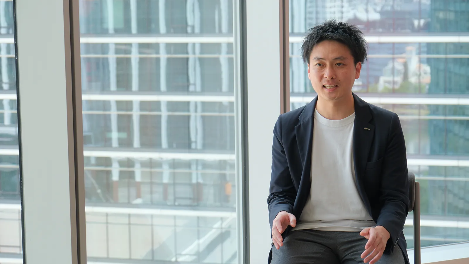 窓を背に話す佐々木さん