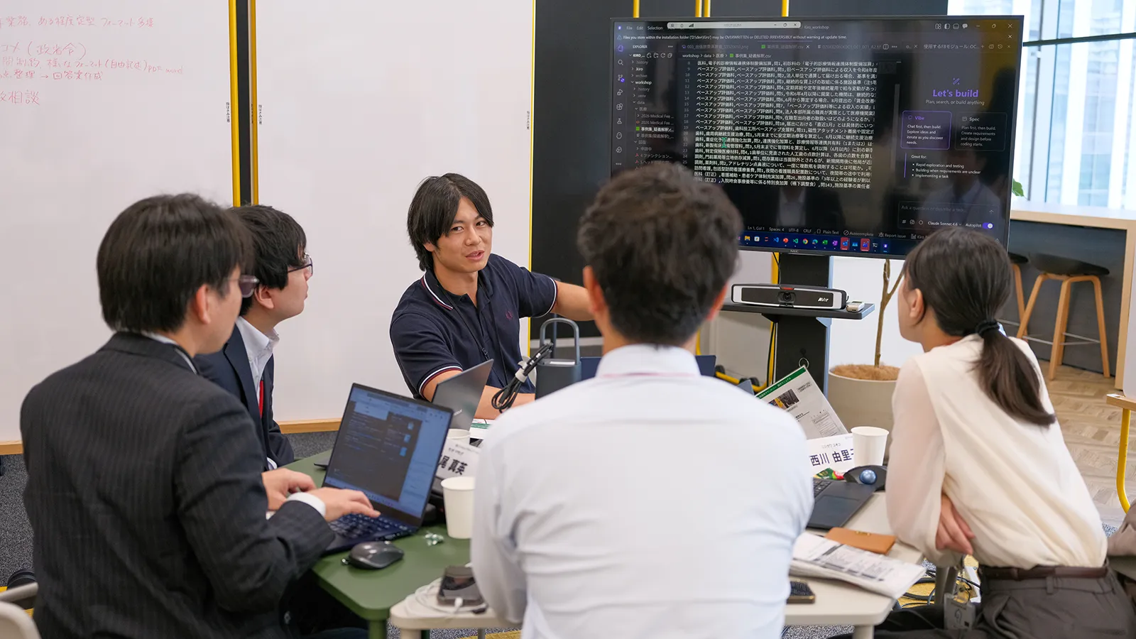 モニターを指しながら説明する男性