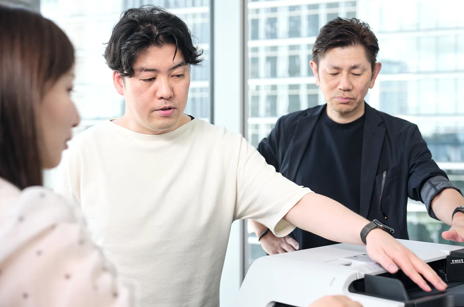 複合機に触れる3人