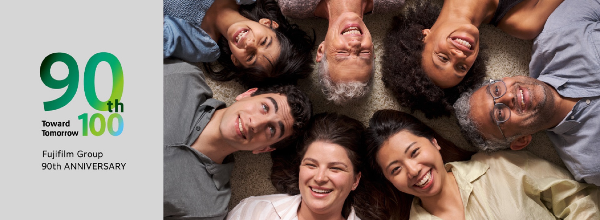 A diverse group of people gathering with smiles, lying down and looking up