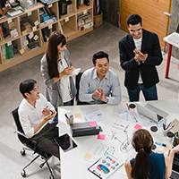 Young professional communicating with coworkers at a virtual meeting.